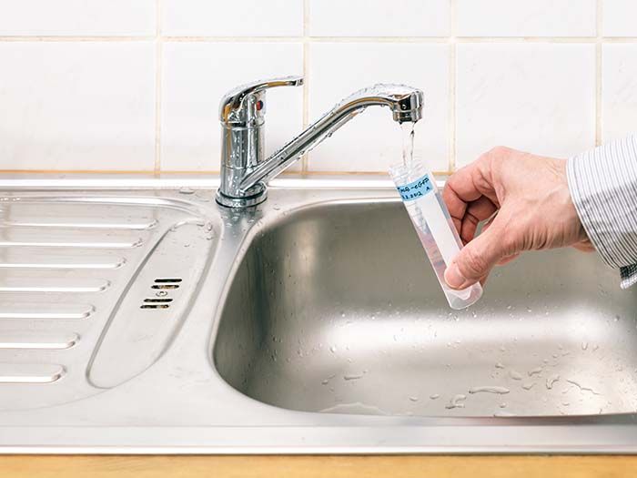 person collecting tap water for water testing