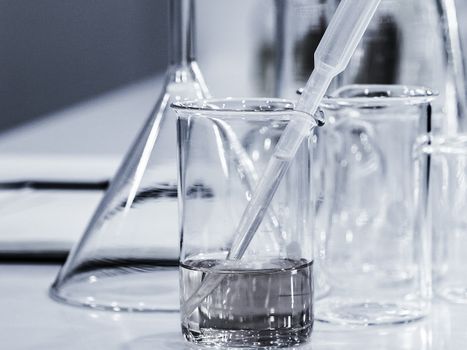 Clear liquid in a glass beaker next to empty beakers