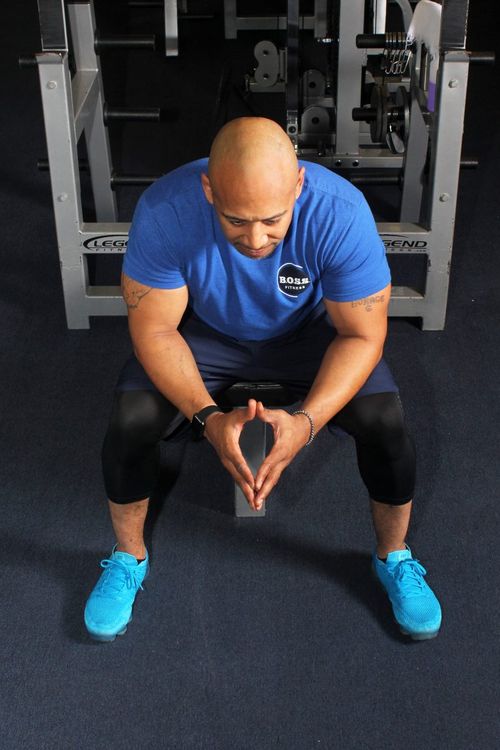 man doing squats in gym