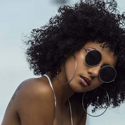 black woman with curly hair in sunglasses