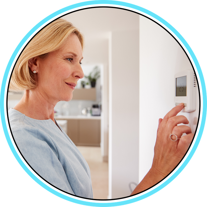 Woman smiling while adjusting her thermostat