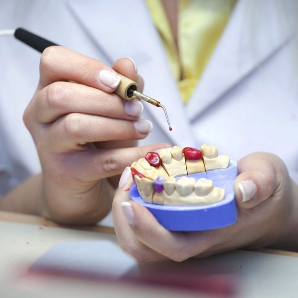 dentist demonstrating implants on model of teeth dentist demonstrating implants on model of teeth