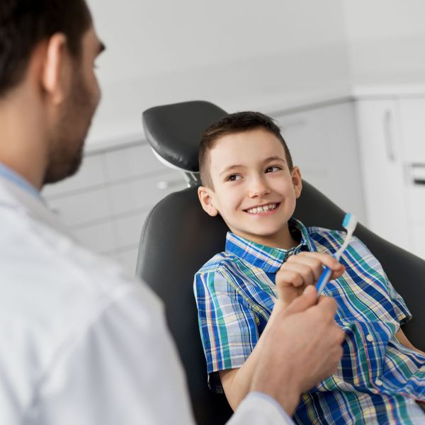 dentist talking with smiling child patient dentist talking with smiling child patient