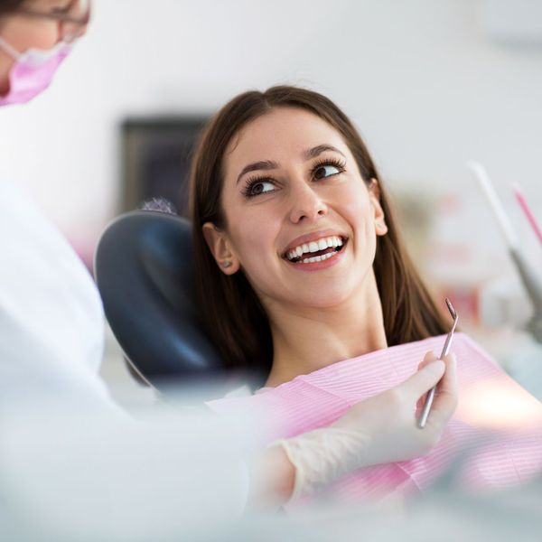 dentist talking with smiling female patient dentist talking with smiling female patient