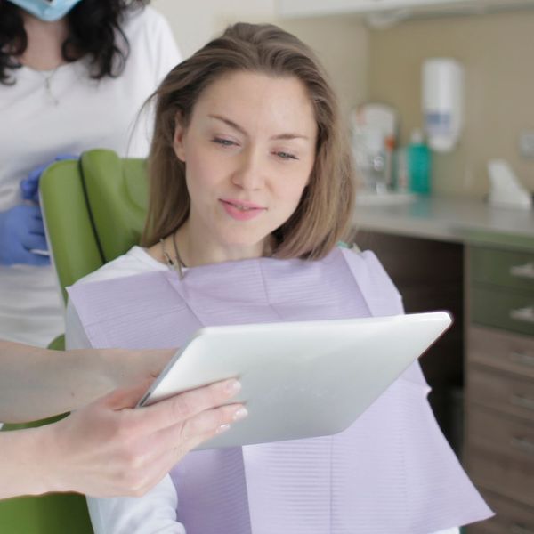 dentist showing woman ipad dentist showing woman ipad