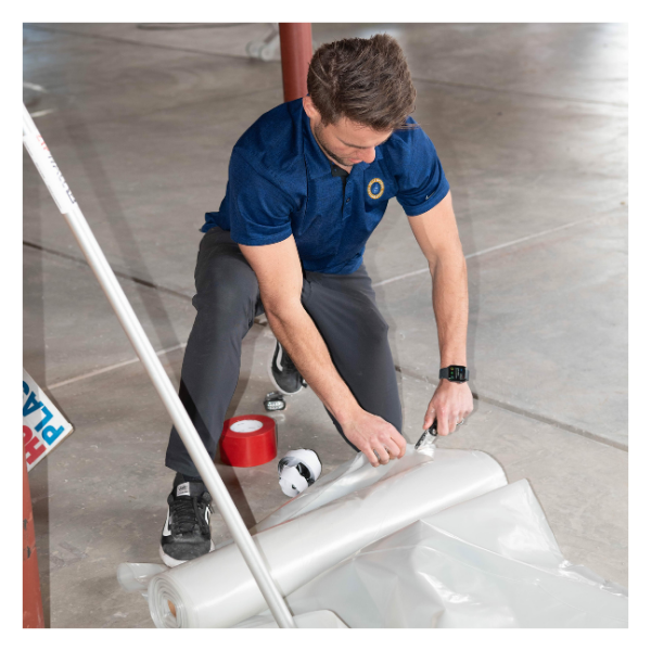 Best Option Restoration technician cutting plastic. 