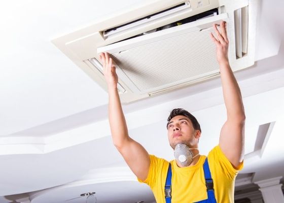 HVAC technician inspecting a duct. HVAC technician inspecting a duct.