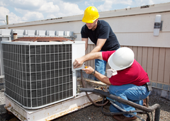 HVAC technicians servicing an AC unit.