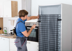HVAC technician fixing a refrigerator. HVAC technician fixing a refrigerator.