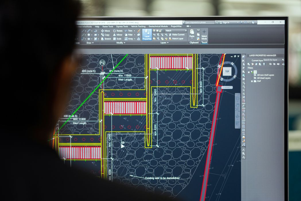 Civil engineer hire looking at drawings on computer Civil engineer hire