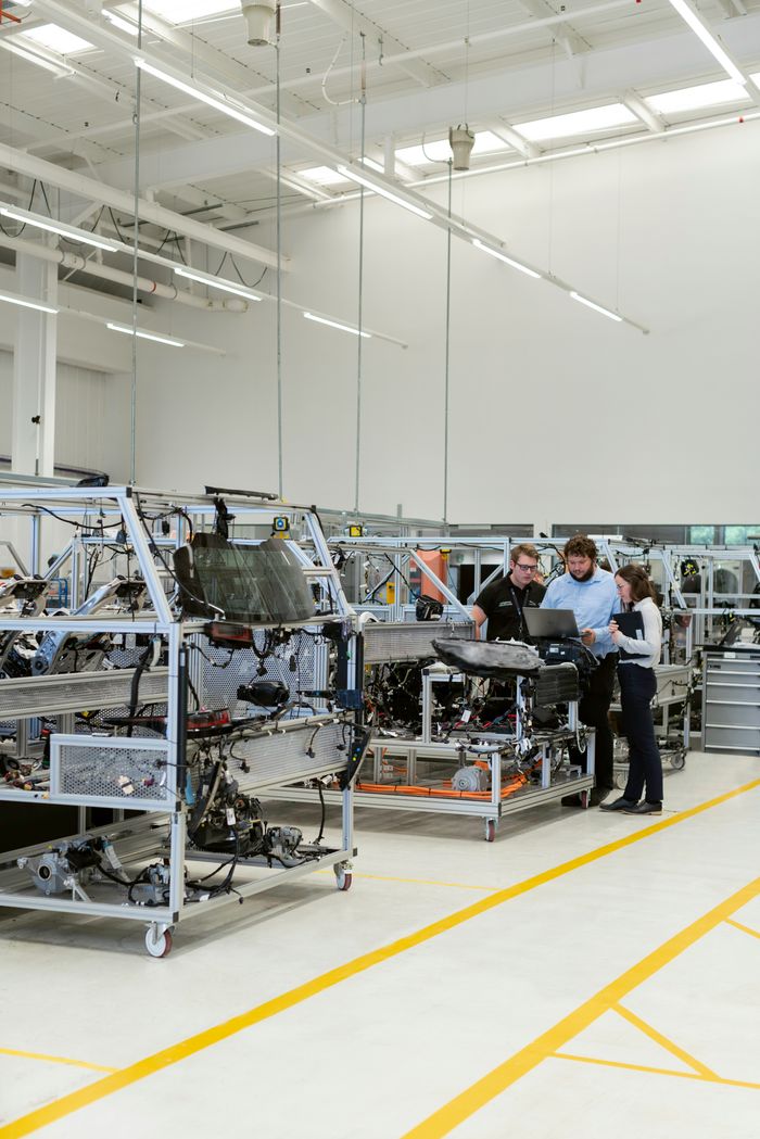 team of engineers work together at a manufacturing facility team of engineers work together on manufacturing floor