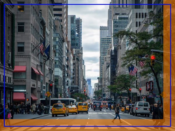 A busy street scene in Manhattan with yellow taxis, pedestrians, and tall buildings under a cloudy sky. A busy street scene in Manhattan with yellow taxis, pedestrians, and tall buildings under a cloudy sky.