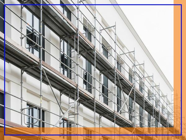 Scaffolding on a modern building facade, indicating ongoing construction or repair work. Scaffolding on a modern building facade, indicating ongoing construction or repair work.