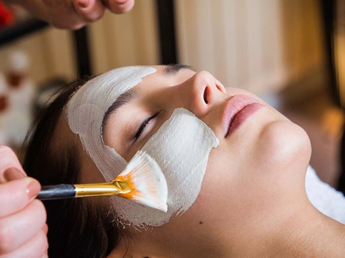 young woman getting a facial mask spa treatment