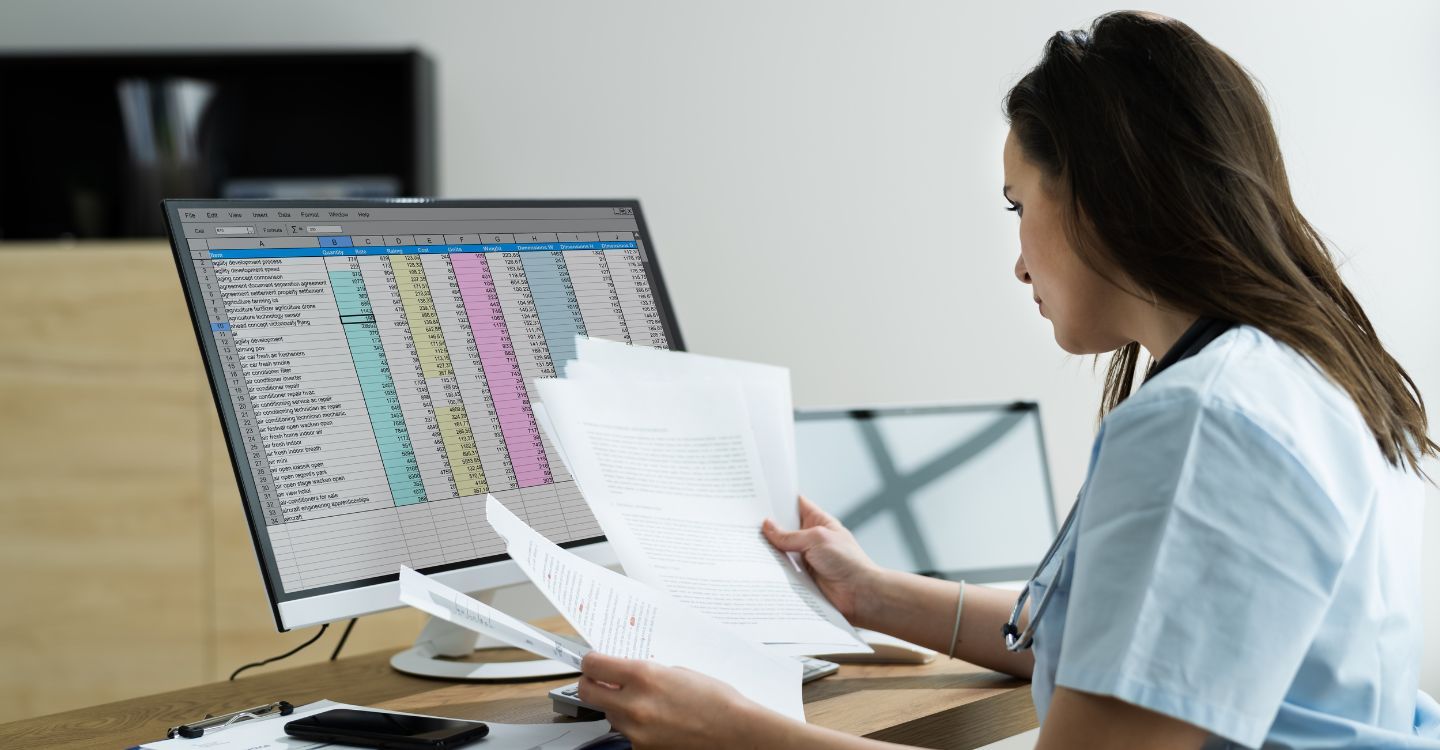 a woman looking at paperwork and medical spreadsheets
