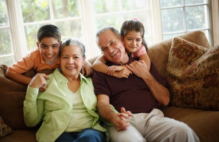 grandparents with grandchildren smiling at home
