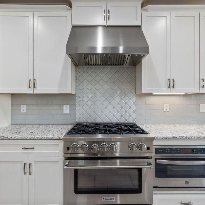 white cabinets around a stove What To Consider When Shopping For New Kitchen Cabinets (3).jpg