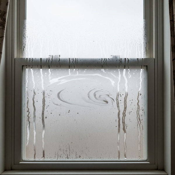 Fog and moisture are visible between the two panes of a failed window seal. Fog and moisture are visible between the two panes of a failed window seal.