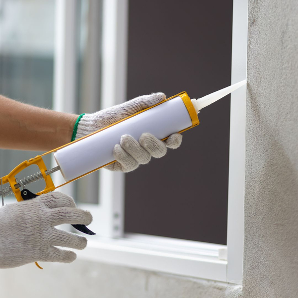 person sealing edge of window