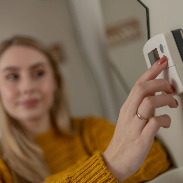 A women changing a thermostat 