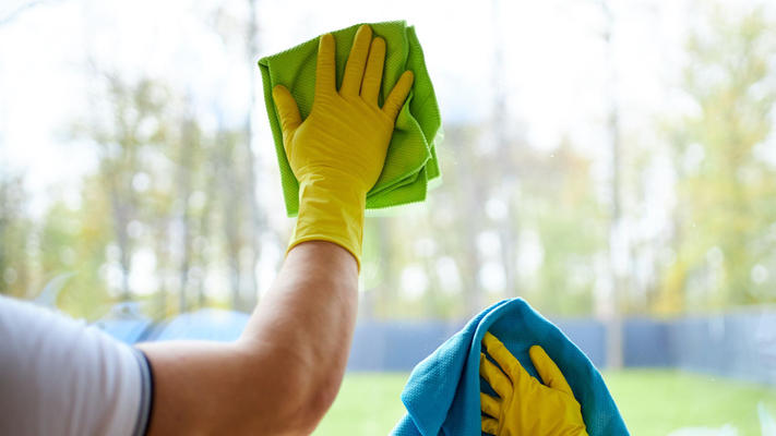 person using microfiber towel to clean window