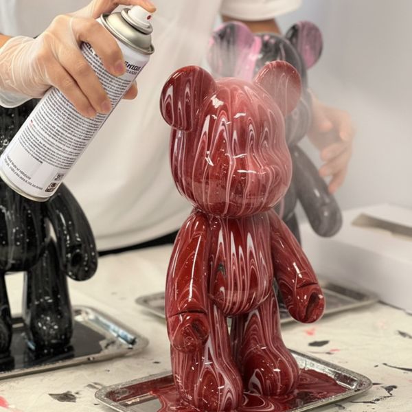 Hand applying clear glossy varnish spray to a finished painted figure. Hand applying clear glossy varnish spray to a finished painted figure.
