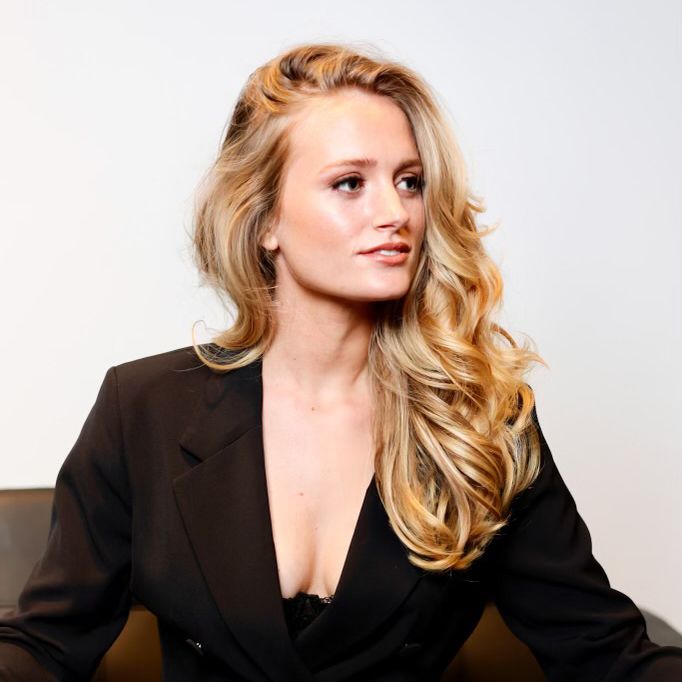 Image of woman with wavy blonde hair wearing a black blazer Hair Extensions Image