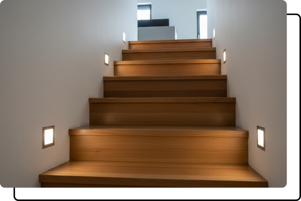 A modern staircase with wooden steps, illuminated by low-profile square LED niches embedded in the wall that provide gentle, ambient pathway lighting.