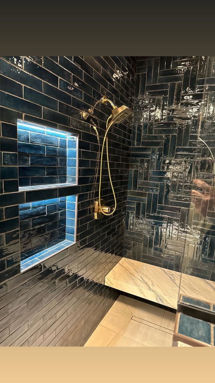 Luxurious navy blue shower with gold accents and Illuminiche niches