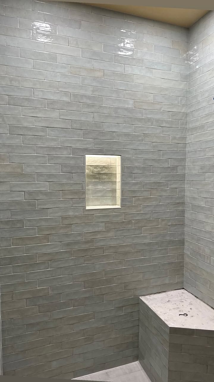 Elegant shower with handmade cream tiles and Illuminiche lighting