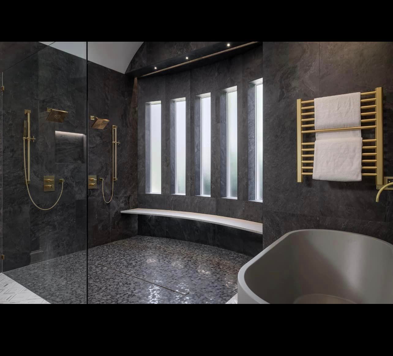 Luxurious Bathroom with Illuminiche Niche, Gold Fixtures, and Tub View