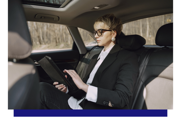 business woman in backseat working