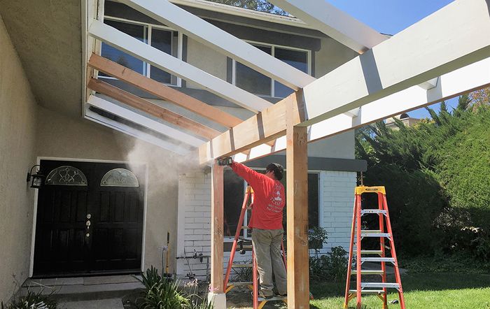 Employee repairing wood structure on home