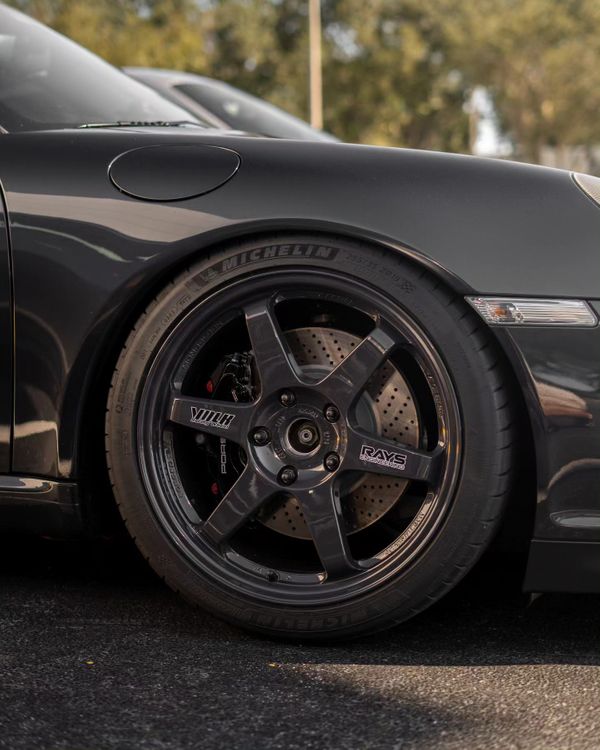 A close-up view of a high-performance sports car alloy wheel and ventilated brake assembly.