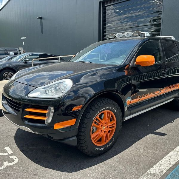 Black Porsche with orange rims and accents