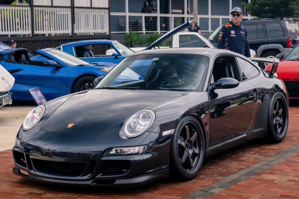 black GT4 with a driver standing beside the car