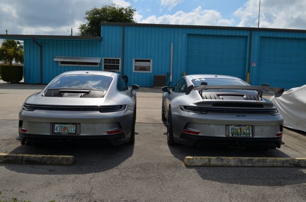 A close up of the back of porsche cars and the exhaust pipes