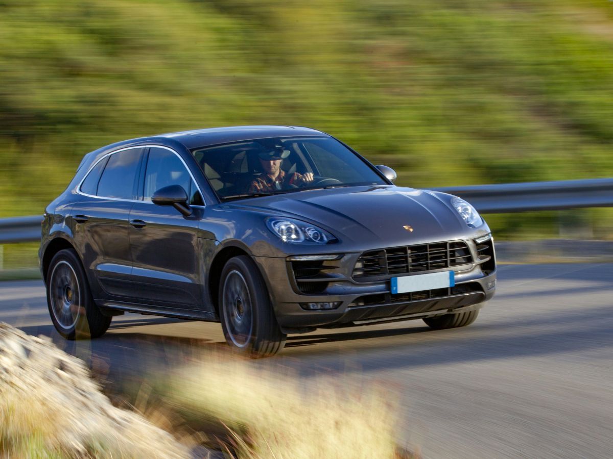 a Porsche Macan driving on the road a Porsche Macan driving on the road