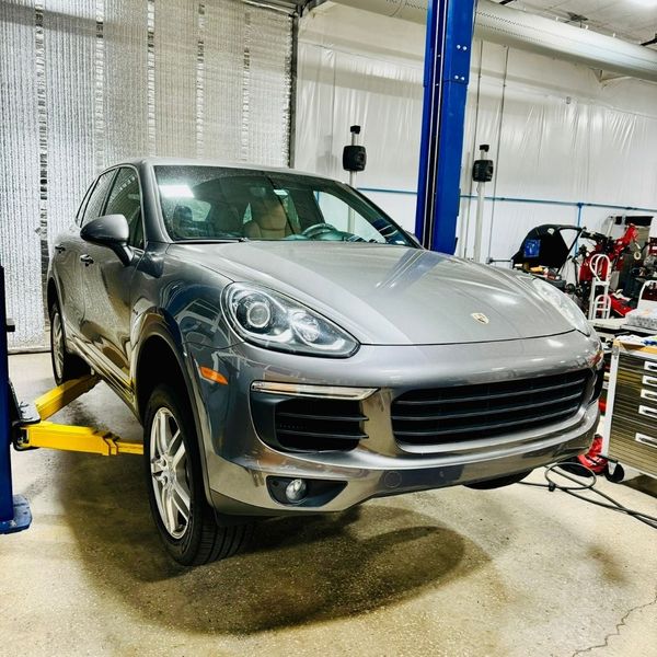 The Silver Porsche is lifted in the repair shop