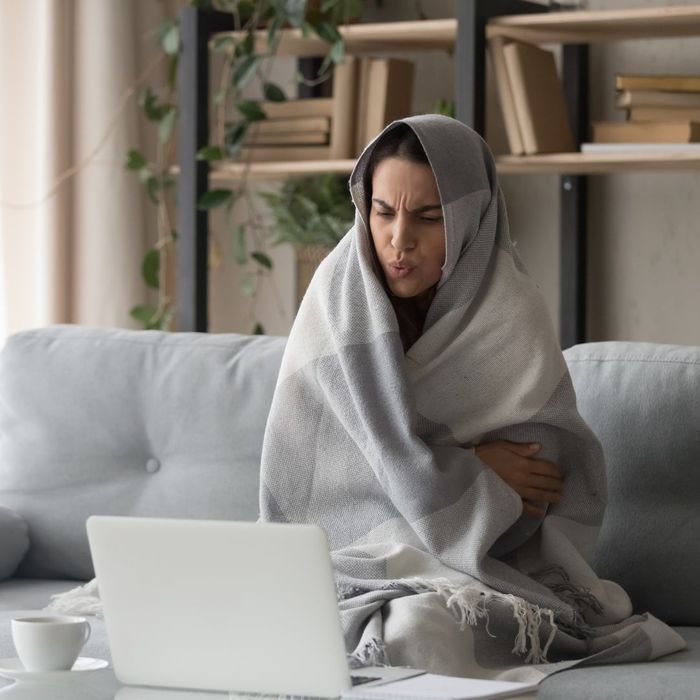 woman wrapped in a blanket in her home