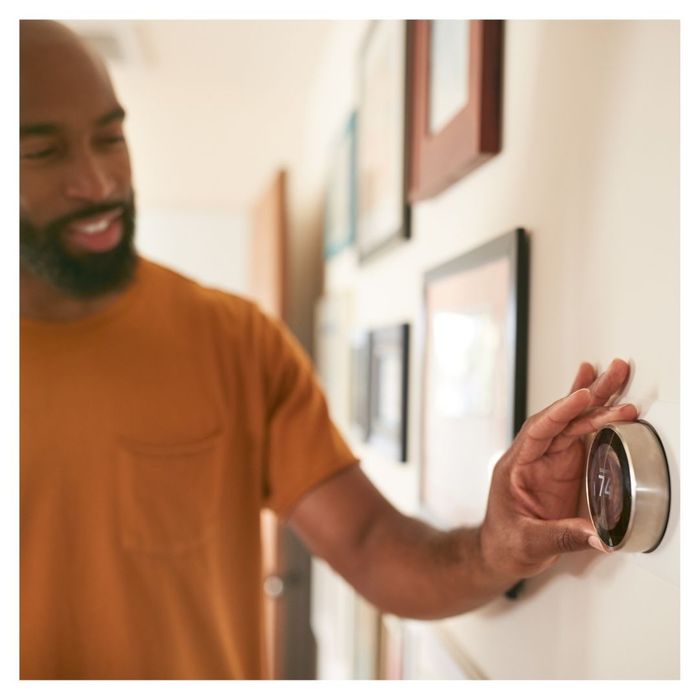 man setting thermostat