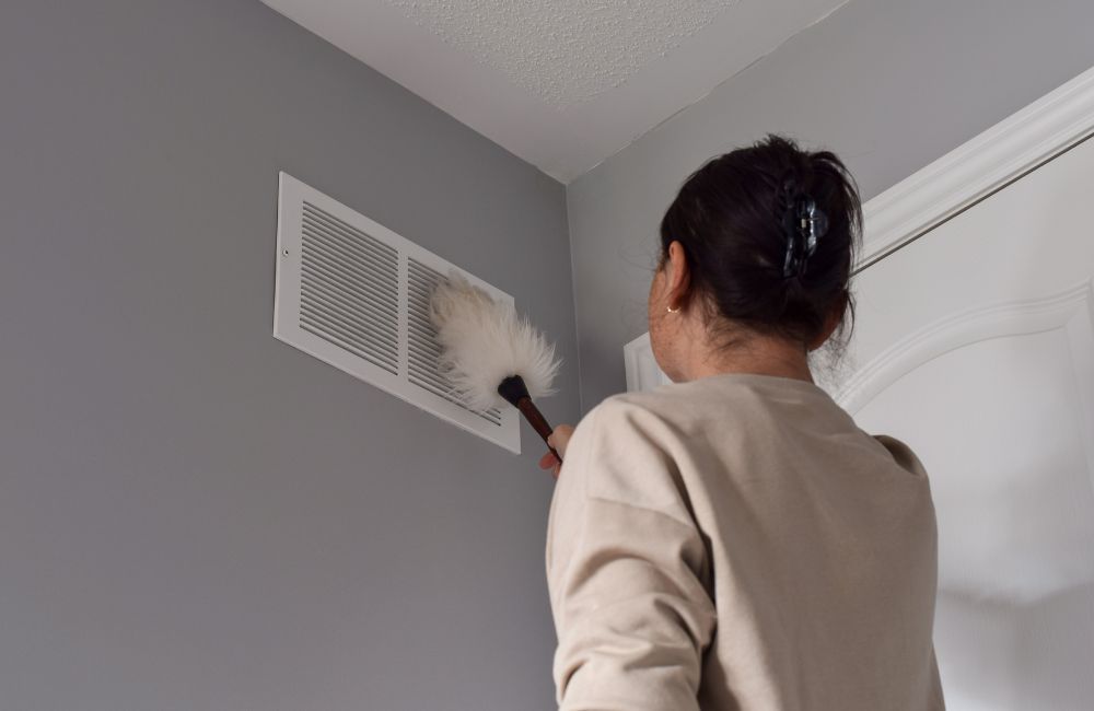 person dusting vent
