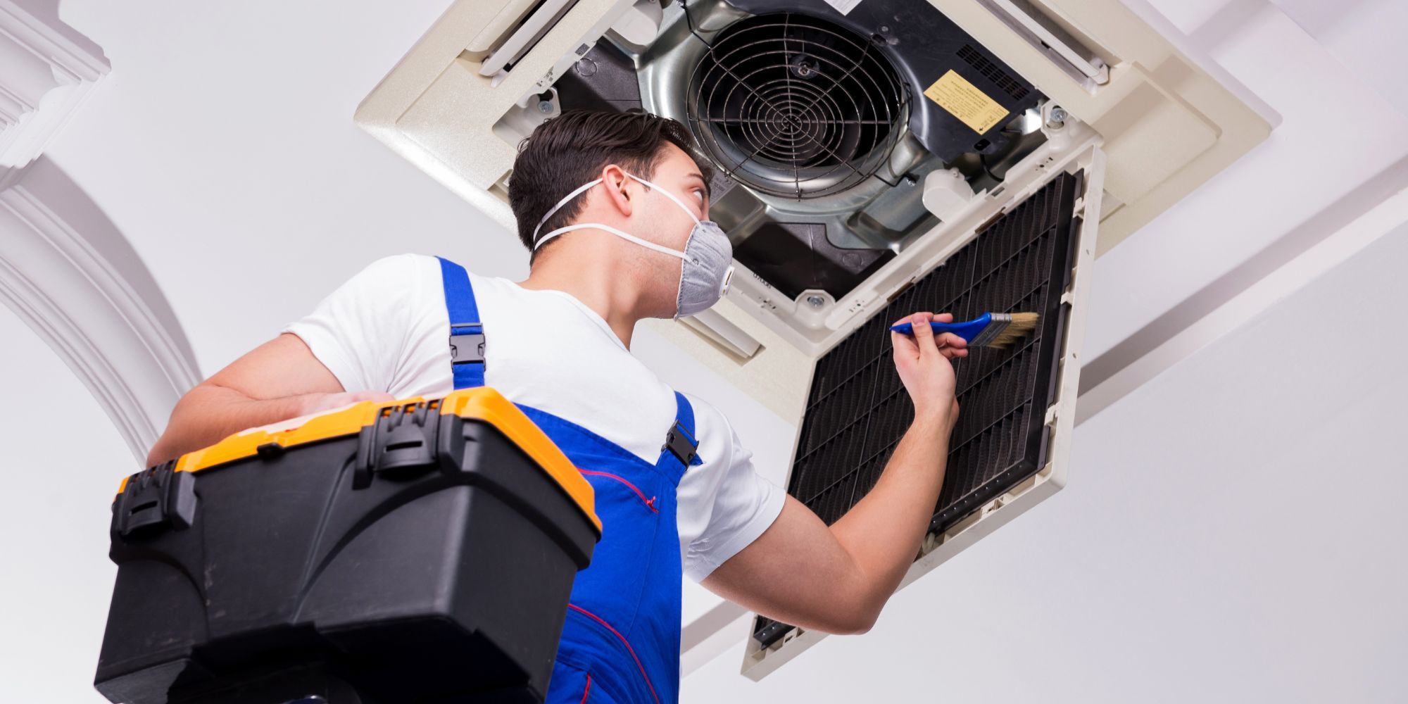 a professional worker cleaning an hvac intake