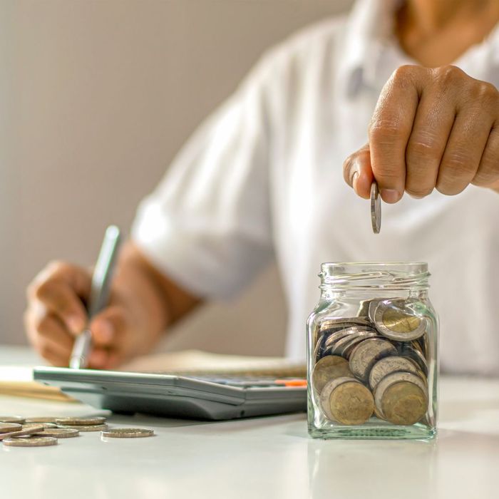person adding money to a money jar
