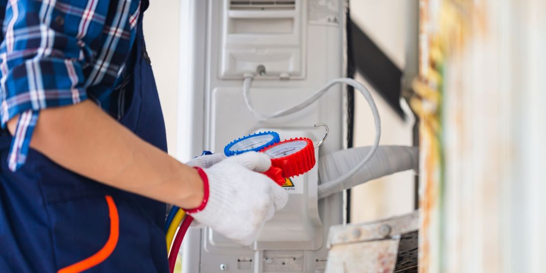 a professional holding an hvac tool and working on an hvac unit