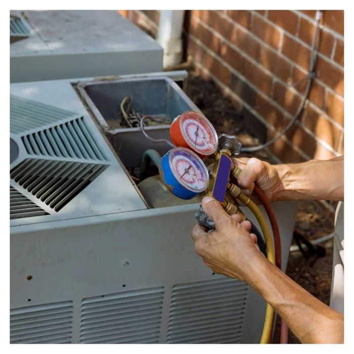 checking pressure gauges on AC unit