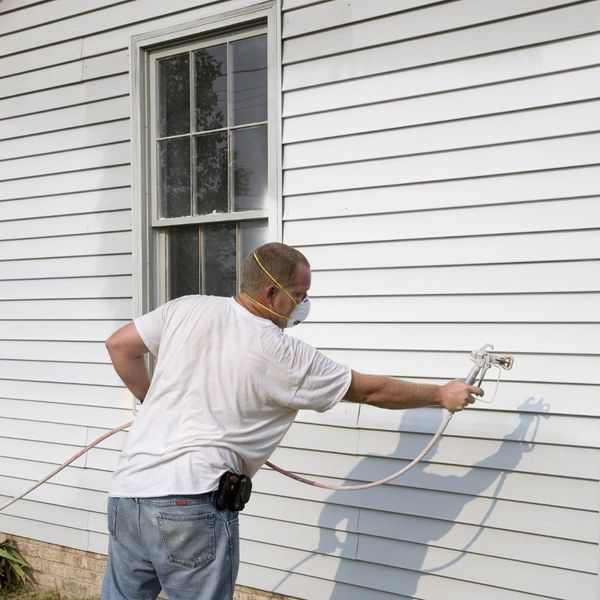 spraying siding of house