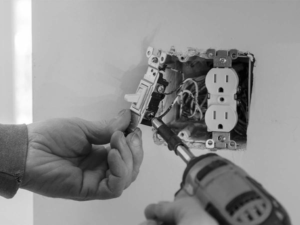 An electrician working with outlet wires
