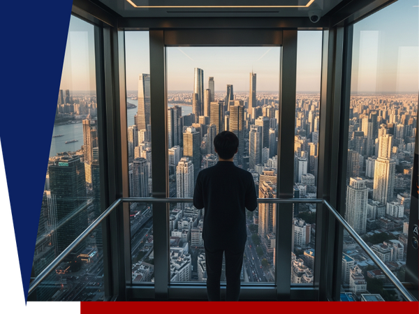 Man in a suit inside a glass elevator, looking out at a modern city skyline at sunset