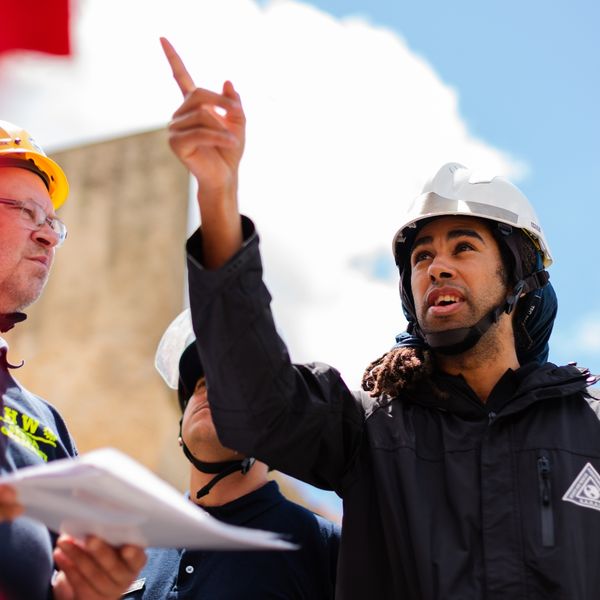 Men wearing hardhats looking up